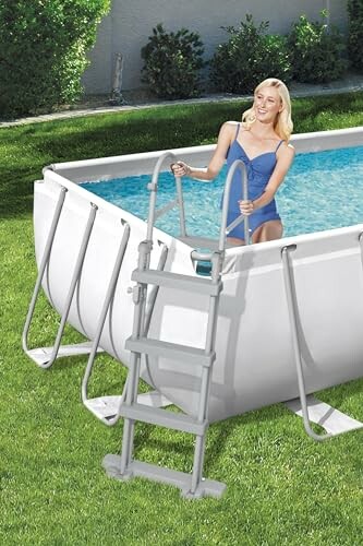 Femme souriante dans une piscine hors-sol avec une échelle.
