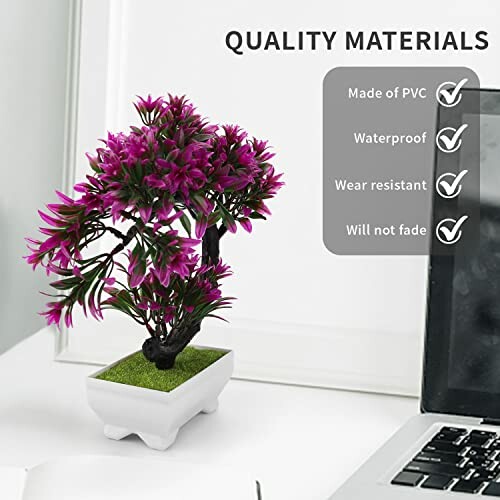 Plante artificielle en pot sur un bureau avec ordinateur portable.