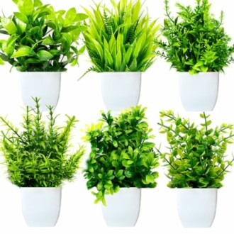 Plantes artificielles vertes dans des pots blancs.