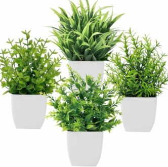 Plantes artificielles dans des pots blancs.