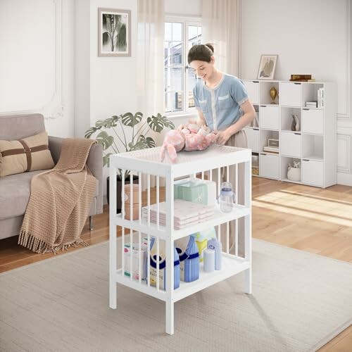 Maman changeant un bébé sur une table à langer dans une chambre.