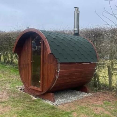 Sauna extérieur en forme de tonneau avec cheminée.