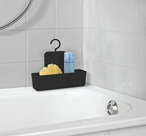 Caddie de bain noir avec éponge et bouteille.
