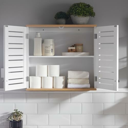 Armoire de salle de bain avec papier toilette et serviettes.