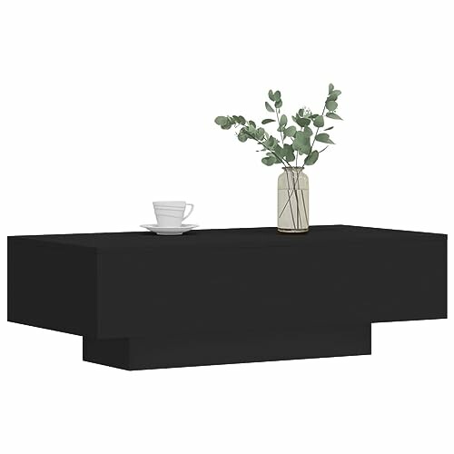 Table basse noire avec vase et tasse