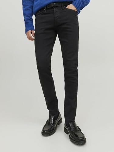 Homme portant un jean noir et un pull bleu.