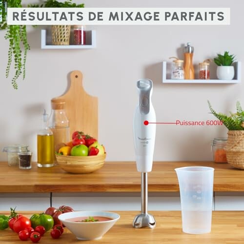 Mixeur plongeant sur un comptoir de cuisine avec légumes et ustensiles.