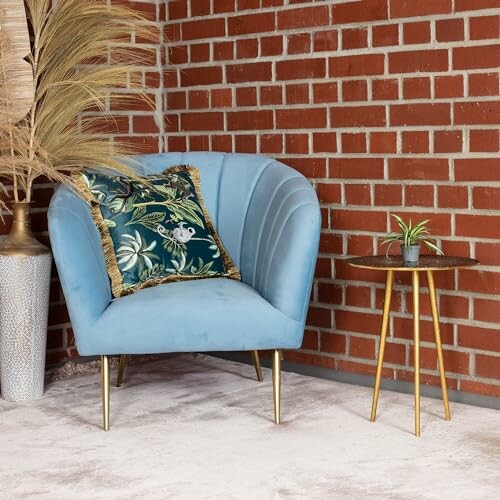 Fauteuil bleu avec coussin floral près d'une table