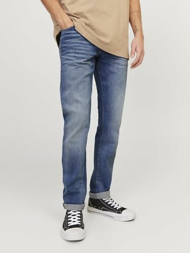 Jeans bleus avec baskets noires et t-shirt beige.