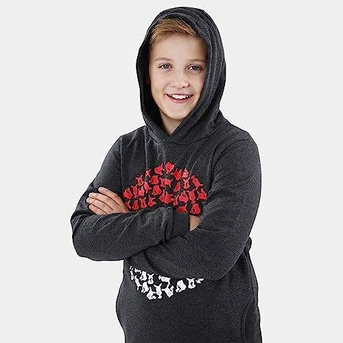 Garçon souriant portant un sweat à capuche.