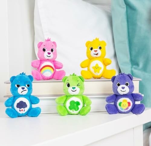 Cinq peluches colorées d'ours sur une étagère.