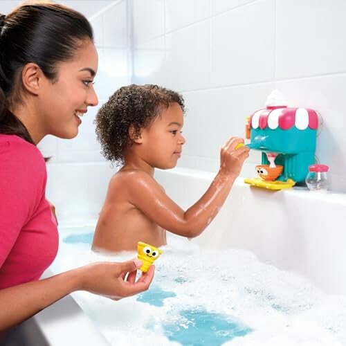 Enfant jouant avec un jouet de bain et un adulte souriant.