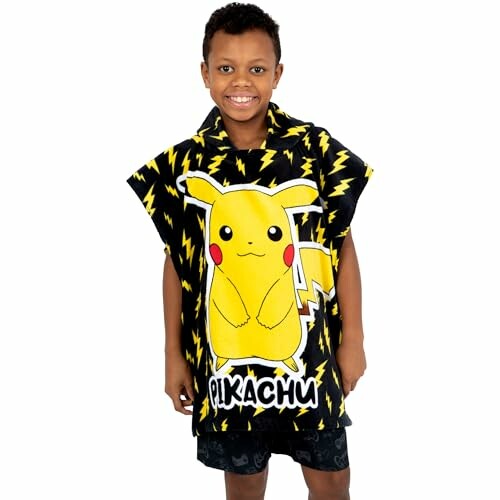 Enfant souriant portant un poncho Pikachu.