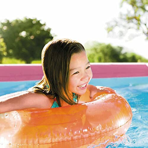 Enfant souriant avec une bouée orange dans une piscine