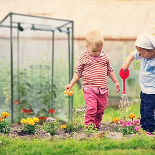 Deux enfants arrosent des plantes dans un jardin.