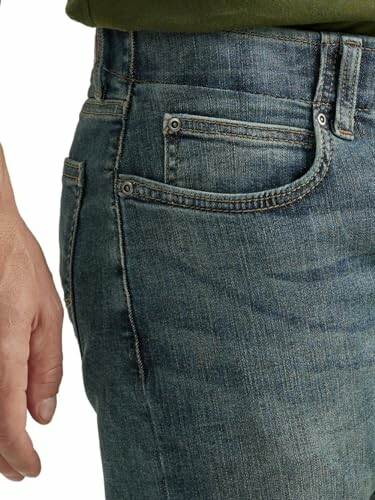 Gros plan sur un jean en denim avec une poche et une main.