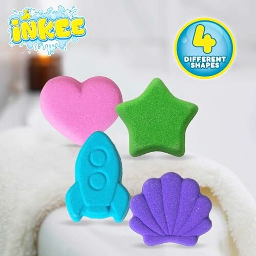 Quatre éponges de bain colorées en forme de cœur, étoile, fusée et coquillage.