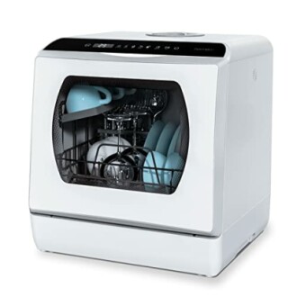Lave-vaisselle compact sur le comptoir avec vaisselle à l'intérieur.