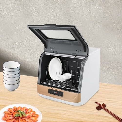 Lave-vaisselle compact sur un comptoir avec vaisselle.