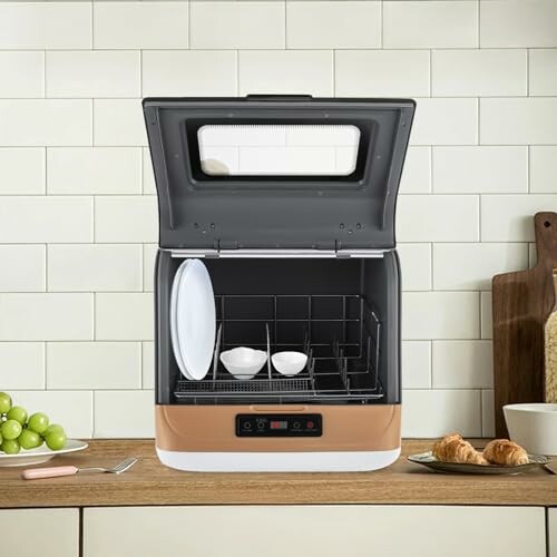 Lave-vaisselle compact sur un comptoir de cuisine avec des assiettes et des bols à l'intérieur.
