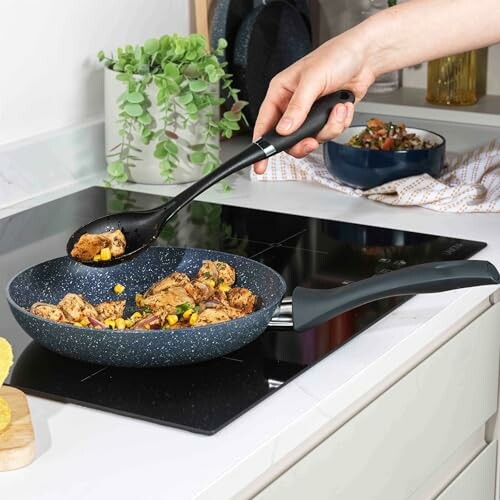 Personne cuisinant des légumes et du poulet dans une poêle sur une cuisinière.