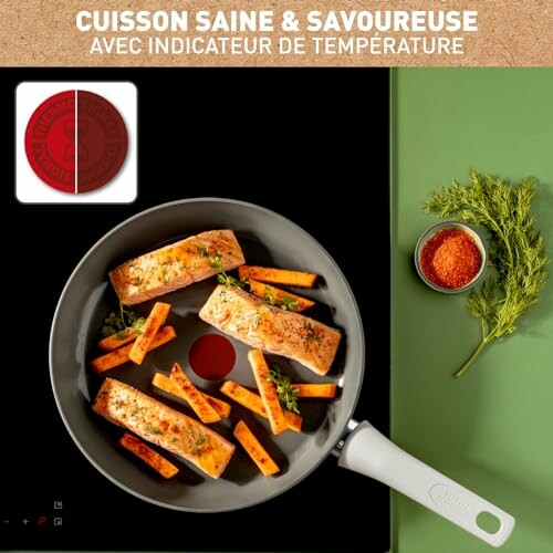 Saumon et légumes cuisinés dans une poêle sur une plaque de cuisson.