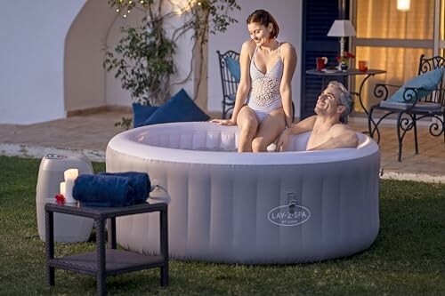 Couple se relaxant dans un jacuzzi gonflable dans le jardin.