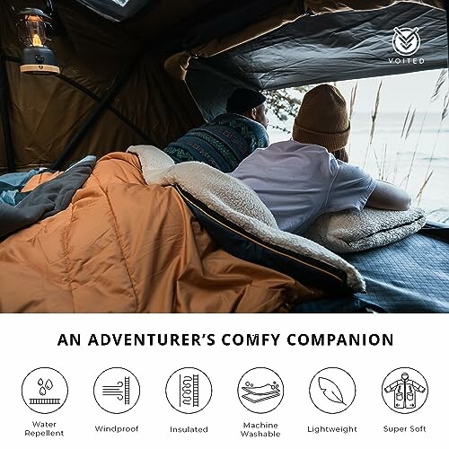 Deux personnes allongées dans un sac de couchage confortable, à l'intérieur d'une tente avec vue sur l'extérieur.
