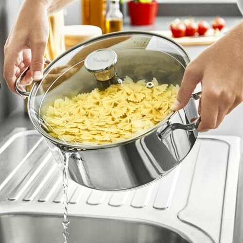 Égouttage des pâtes dans une casserole en acier inoxydable.