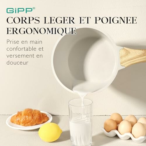 Poêle ergonomique versant du lait dans un verre, avec des œufs, un citron et une pâtisserie à côté.