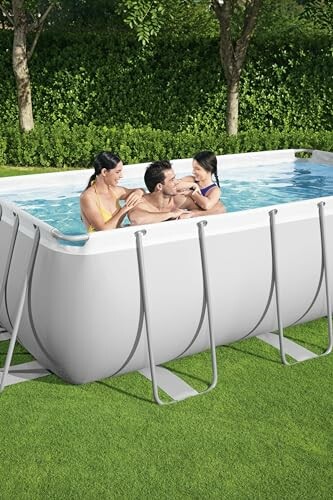 Famille profitant d'une piscine rectangulaire dans le jardin.