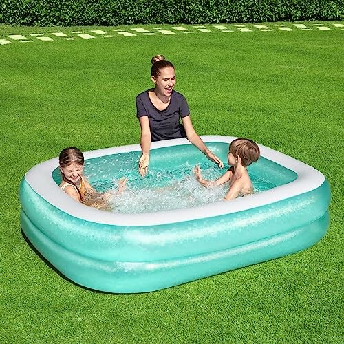 Une femme et deux enfants jouant dans une piscine gonflable.