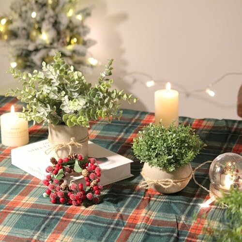 Table décorée avec des bougies, des plantes et des lumières de Noël.