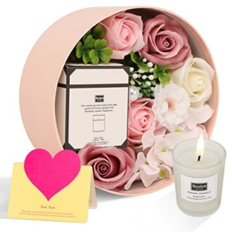 Ensemble cadeau avec bougie parfumée et fleurs.