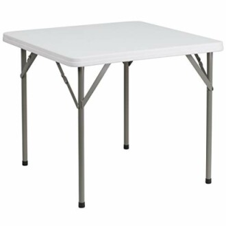 Table pliante carrée blanche avec pieds métalliques.