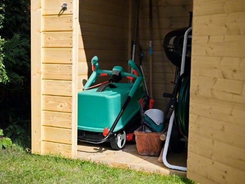 Tondeuse et outils de jardin dans un abri