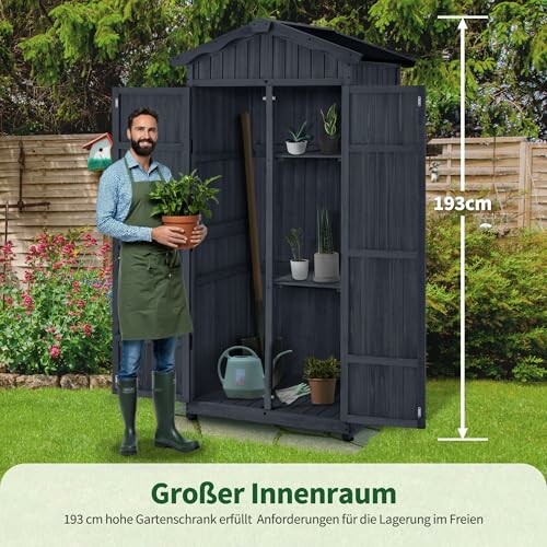 Homme tenant une plante devant un cabinet de jardin ouvert.