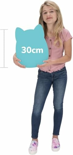 Fille tenant un coussin en forme de chat de 30 cm.
