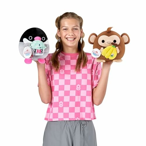 Fille tenant des peluches en forme de pingouin et de singe.