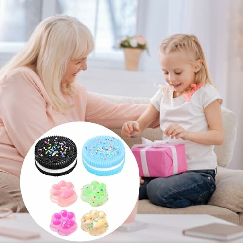Grand-mère donnant un cadeau à une petite fille avec des jouets en forme de biscuits.