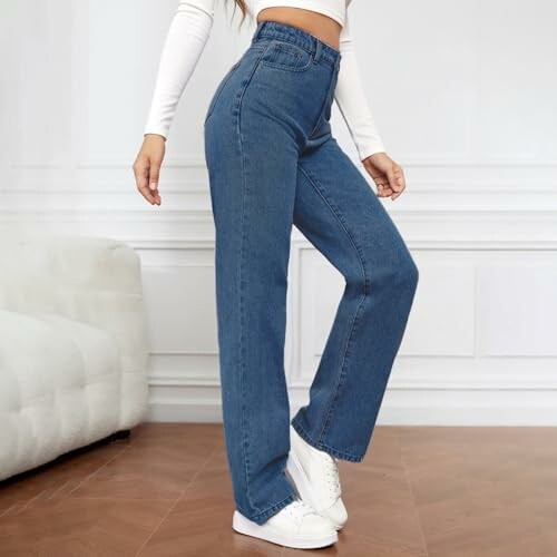 Personne portant un jean taille haute et un haut blanc.