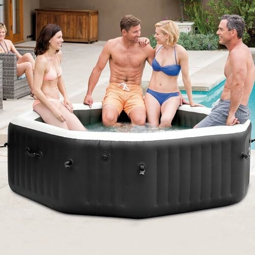 Quatre personnes dans un jacuzzi gonflable près d'une piscine.