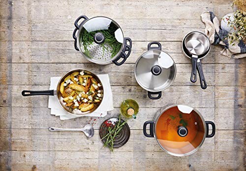 Ensemble de casseroles et poêles sur une table en bois.