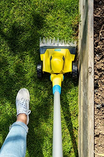 Outil de découpe de pelouse jaune utilisé le long d'un bord en bois.