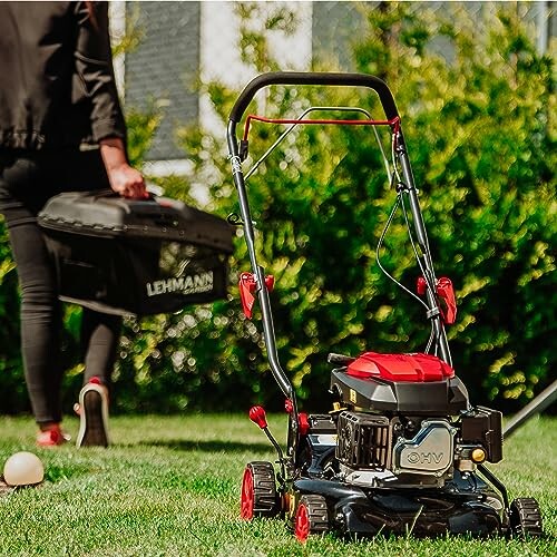 Tondeuse à gazon sur l'herbe avec une personne en arrière-plan.