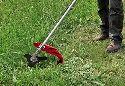 Personne utilisant une débroussailleuse pour couper l'herbe.