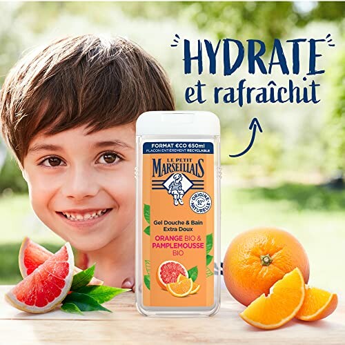 Enfant souriant avec gel douche Le Petit Marseillais à l'orange et pamplemousse