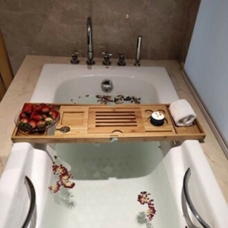 Bain avec plateau en bois, fraises et bougie.