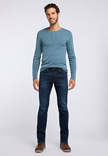 Homme portant un pull bleu et un jean.