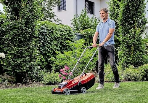 Homme tondant la pelouse dans un jardin.